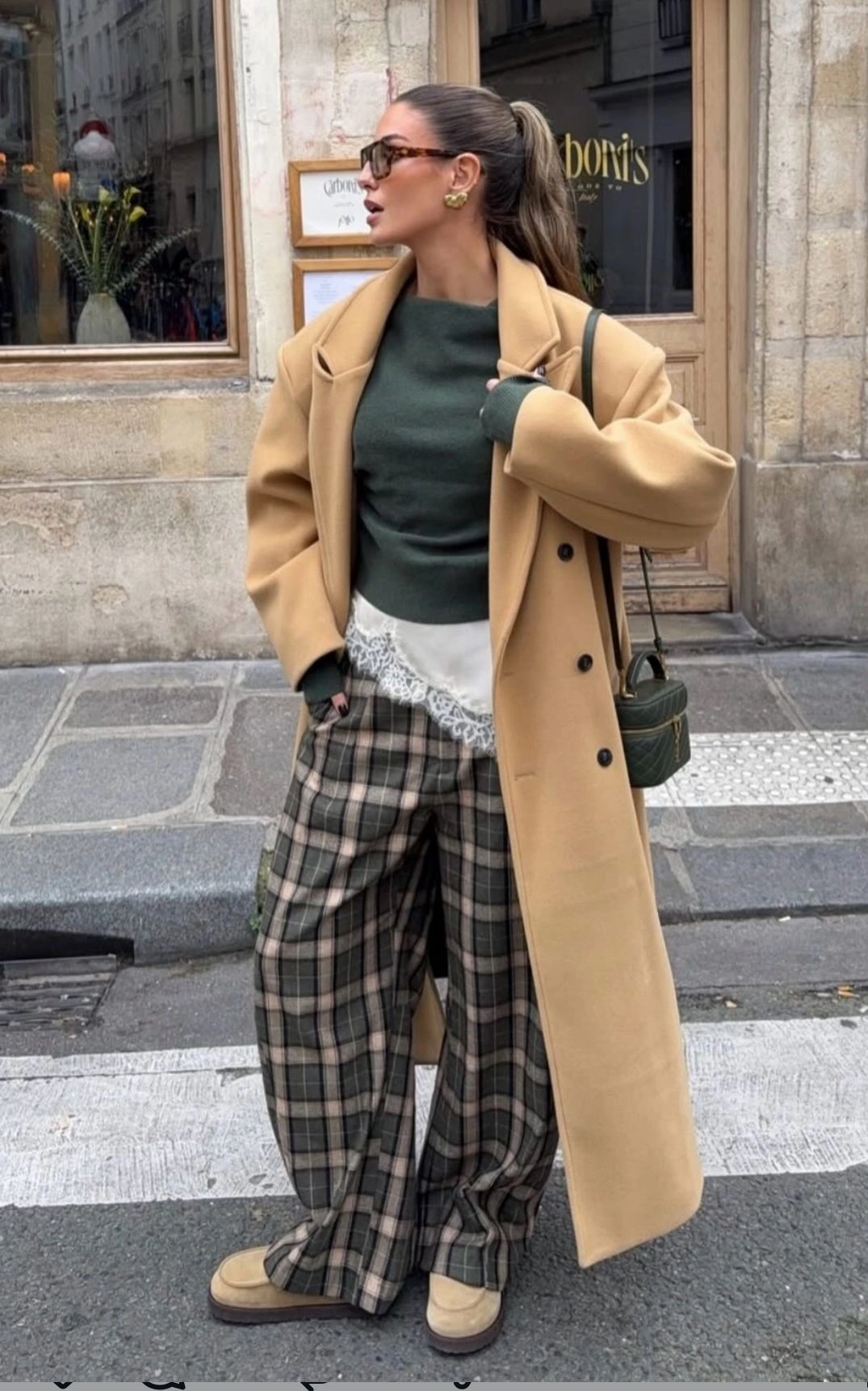 Картаті штани в коричнево-оливкову клітинку з довгим бежевим пальтом на осінь